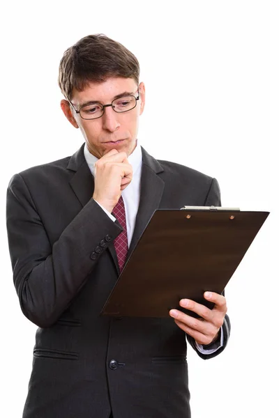 Captura de estudio de hombre de negocios leyendo en el portapapeles mientras pensaba — Foto de Stock