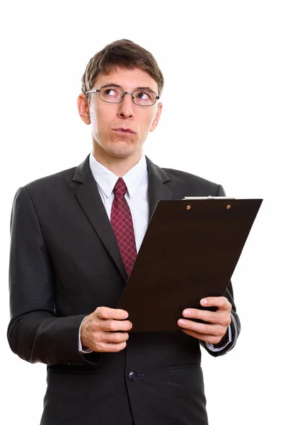 Studio shot of businessman holding clipboard while thinking — Stock Photo, Image
