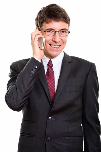 Studio shot of happy businessman smiling while talking on mobile — Stock Photo, Image