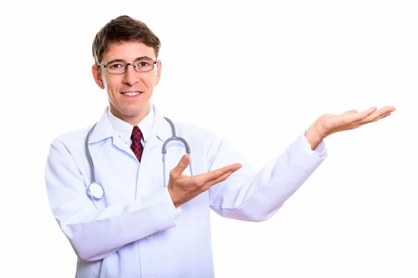 Estudio de tiro de hombre feliz médico sonriendo mientras muestra algo —  Fotos de Stock