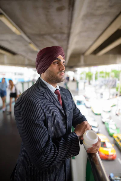Jeune bel homme d'affaires indien sikh vêtu de turban à l'extérieur en ville — Photo