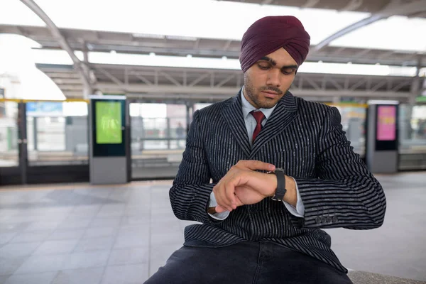 Homme d'affaires indien vérifiant l'heure de la montre intelligente à la gare — Photo