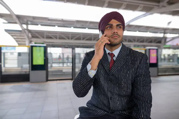 Indian businessman talking on phone at train station — Stock Photo, Image