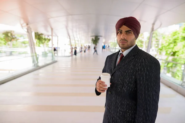 Homme d'affaires indien avec turban en plein air dans la ville tenant tasse de café — Photo
