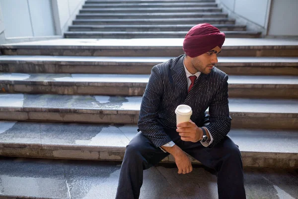 Portrait d'un homme d'affaires indien assis dans un escalier à l'extérieur en ville — Photo