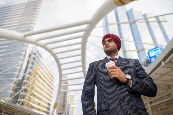 Portrait of Indian businessman with turban outdoors in city