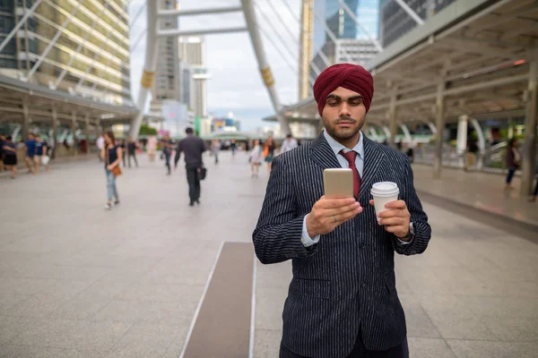 Indian businessman outdoors in city using mobile phone — Stock Photo, Image