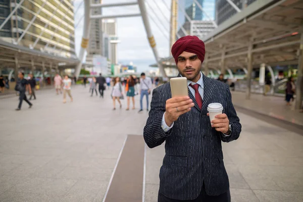 Indian businessman outdoors in city using mobile phone — Stock Photo, Image