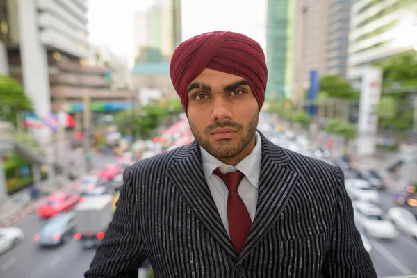 Portrait of Indian businessman with turban outdoors in city