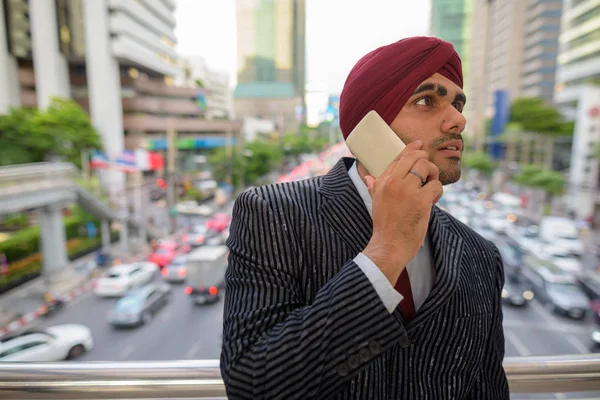 Homme d'affaires indien avec turban à l'extérieur en ville parlant au téléphone — Photo