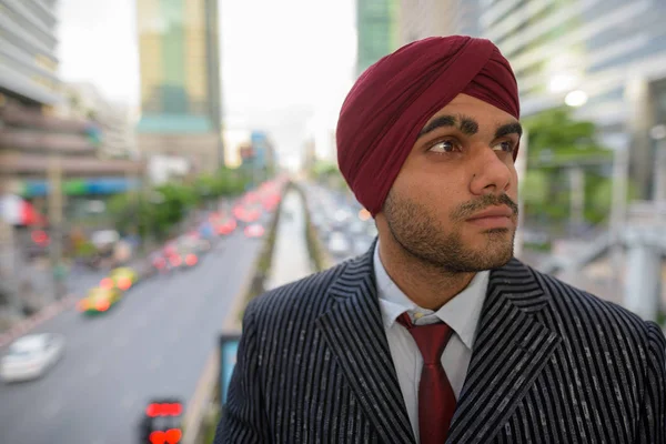 Retrato de empresário indiano com turbante ao ar livre no pensamento da cidade — Fotografia de Stock