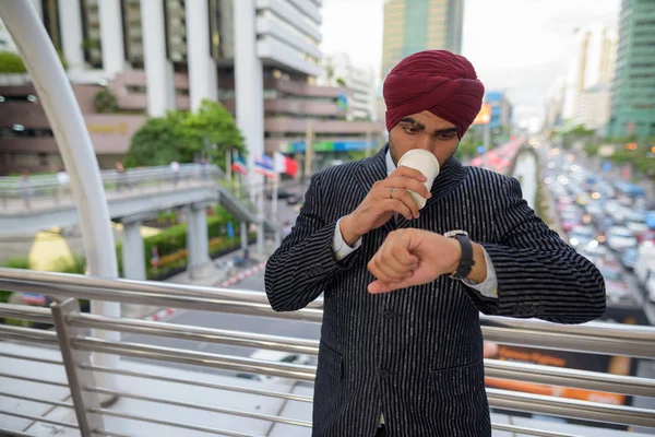 Homme d'affaires à l'extérieur en ville vérifier l'heure de regarder et de boire du café — Photo