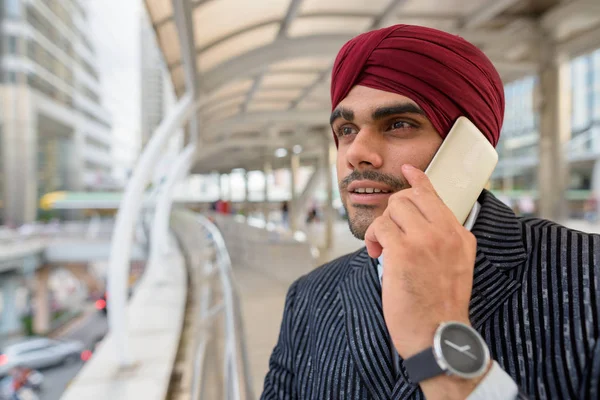 Homme d'affaires indien avec turban à l'extérieur en ville parlant au téléphone — Photo