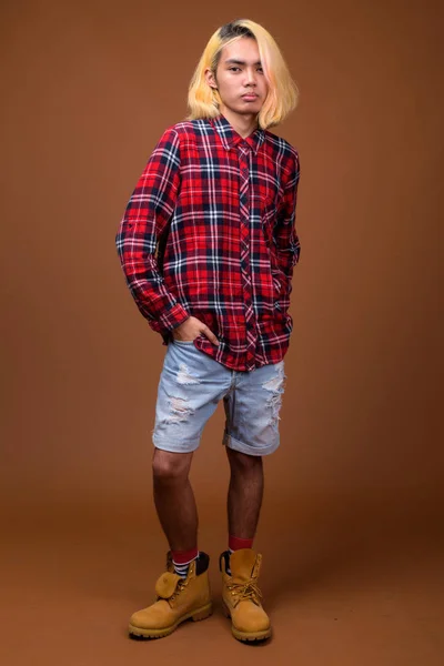 젊은 아시아 남자 갈색 배경 세련 된 옷을 입고 — 스톡 사진