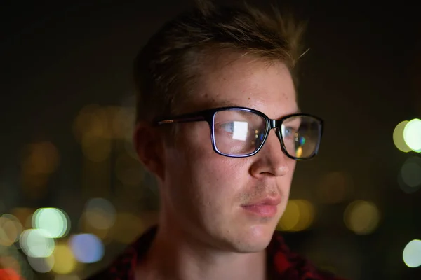 Cara de joven guapo hombre con gafas que piensa en la noche —  Fotos de Stock