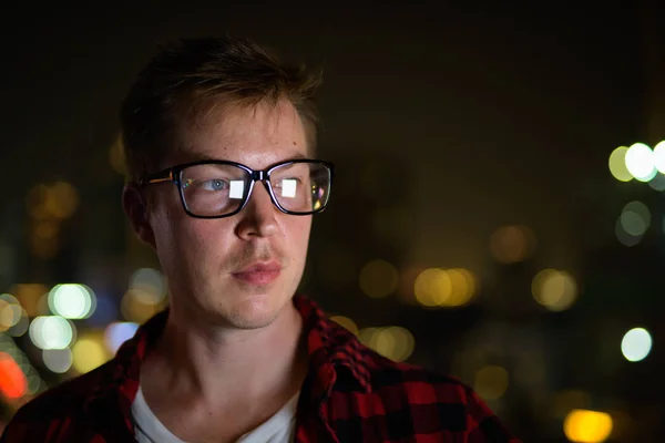 Gezicht van jonge knappe Hipster Man denken tegen uitzicht over de stad — Stockfoto