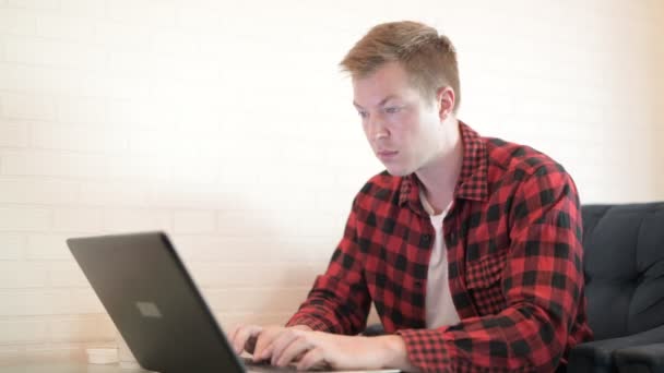 Jovem bonito hipster homem usando telefone e laptop no o café — Vídeo de Stock