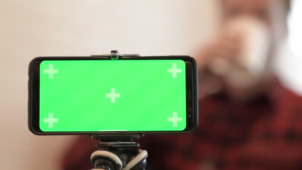 Teléfono con pantalla verde contra el joven hombre Hipster en el fondo — Vídeos de Stock