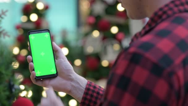 Vue arrière du jeune homme hipster utilisant le téléphone contre les arbres de Noël à l'extérieur — Video