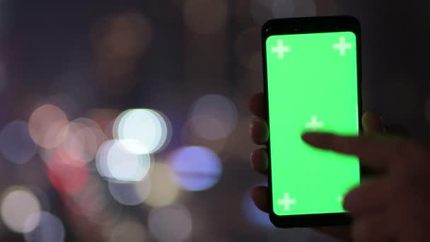 Ręce młodego człowieka przy użyciu telefonu z widokiem na miasto w nocy — Wideo stockowe