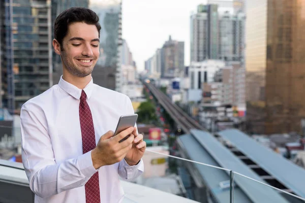 Πορτρέτο των νέων όμορφος επιχειρηματίας στην πόλη χρησιμοποιώντας το τηλέφωνό — Φωτογραφία Αρχείου