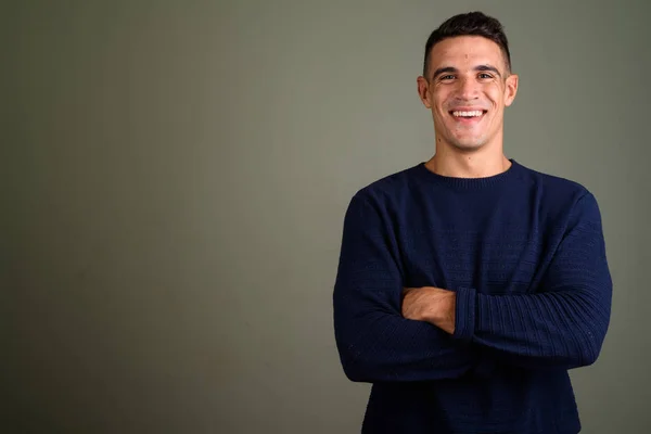 Young handsome man wearing sweater against colored background — Stock Photo, Image