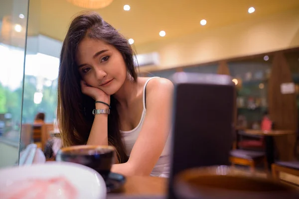 Jonge mooie Aziatische toeristische vrouw vlogging in restaurant met mobiele telefoon — Stockfoto
