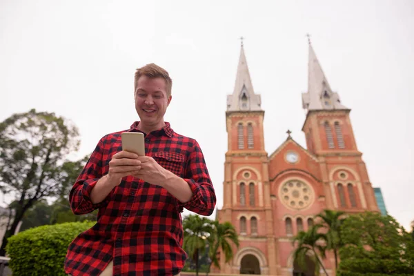 Touristenmann telefoniert vor der Kathedrale Notre Dame in der Stadt Ho Chi Minh — Stockfoto