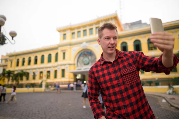 Туристична людина за допомогою телефону перед Сайгон Головпоштамту — стокове фото