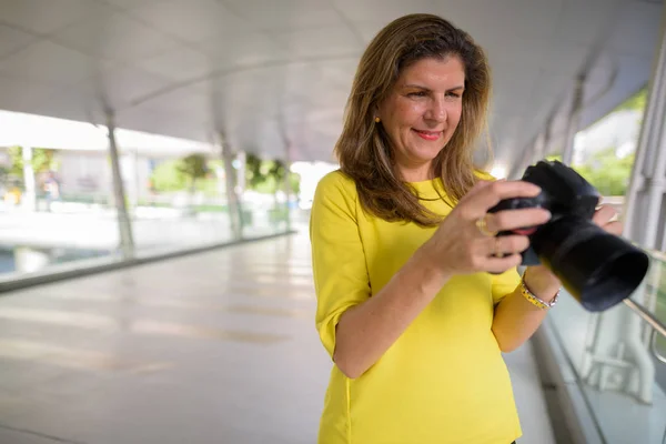 Heureux mature photographe femme à l'aide de caméra à l'extérieur — Photo