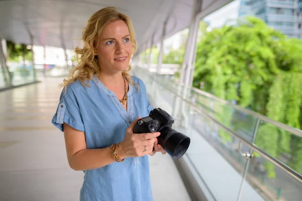 Krásná blondýna turistické žena fotograf pomocí fotoaparátu venku — Stock fotografie