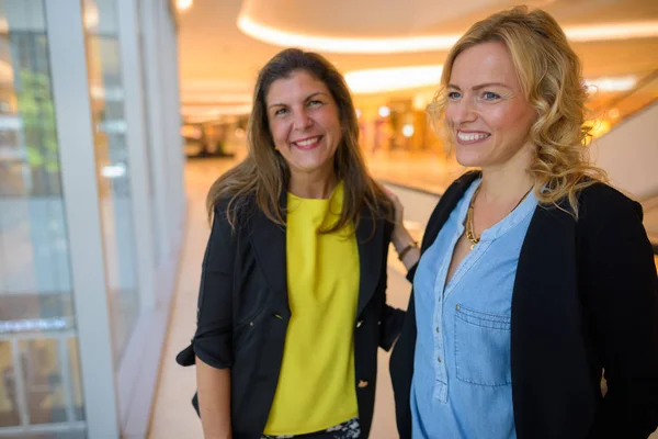 Portrét dvou šťastné podnikatelky uvnitř nákupního centra — Stock fotografie