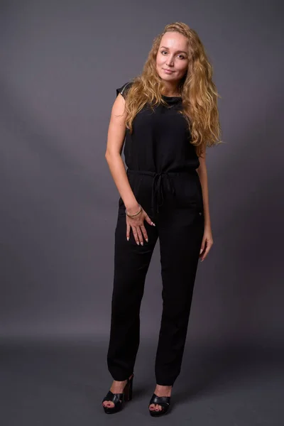 Young beautiful businesswoman with long wavy blond hair against — Stock Photo, Image