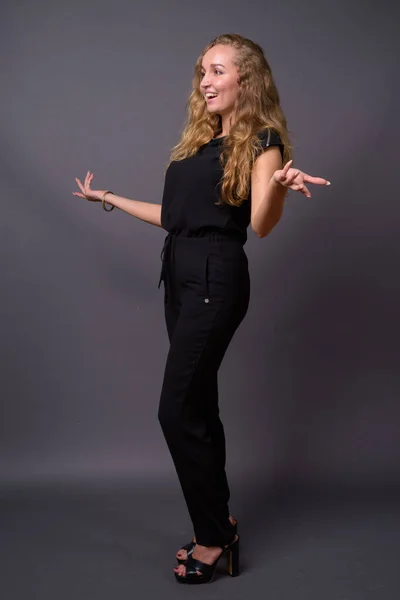 Young beautiful businesswoman with long wavy blond hair against — Stock Photo, Image