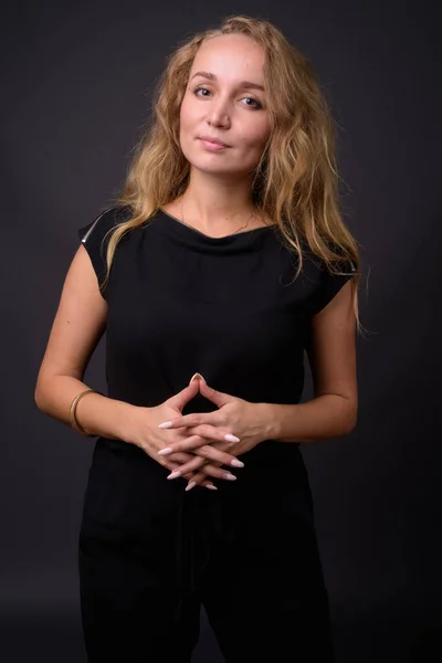 Young beautiful businesswoman with long wavy blond hair against — Stock Photo, Image