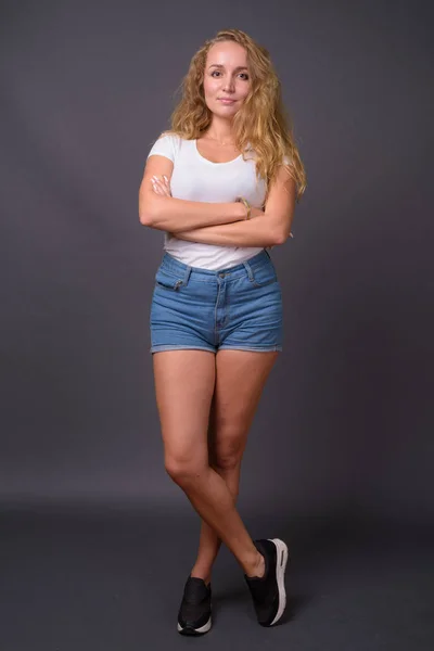 Retrato de comprimento total de jovem mulher bonita com cabelo loiro ondulado longo — Fotografia de Stock