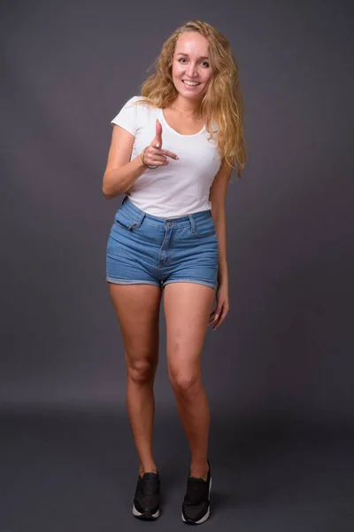 Retrato de comprimento total de jovem mulher bonita com cabelo loiro ondulado longo — Fotografia de Stock