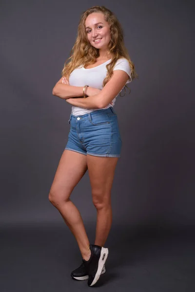 Retrato de comprimento total de jovem mulher bonita com cabelo loiro ondulado longo — Fotografia de Stock