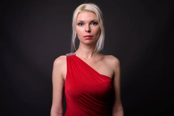 Hermosa mujer con cabello rubio usando vestido rojo —  Fotos de Stock