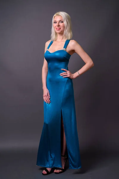 Full length portrait of beautiful woman with blond hair wearing blue dress — Stock Photo, Image