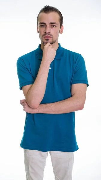 Studio shot of young bearded man standing while thinking against — Stock Photo, Image