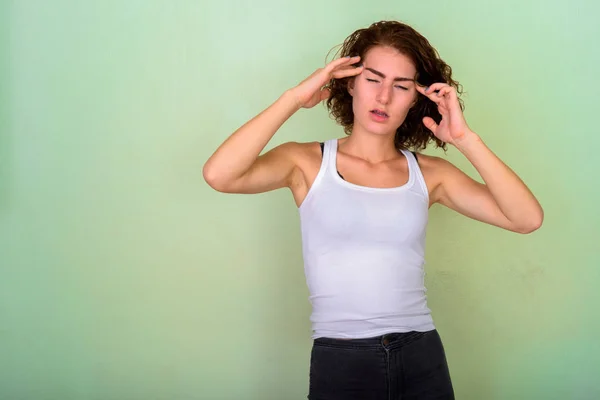 Studio skott av stressade tonårig flicka att ha huvudvärk mot gre — Stockfoto