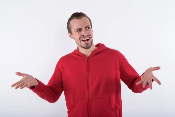 Estúdio tiro de jovem homem barbudo feliz olhando confuso enquanto th — Fotografia de Stock