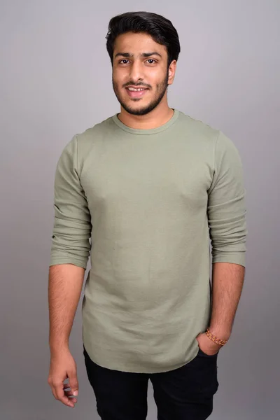 Porträt eines jungen gutaussehenden indischen Mannes vor grauem Hintergrund — Stockfoto
