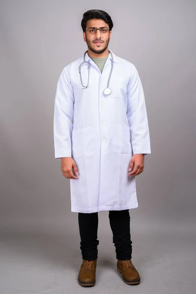 Porträt eines indischen Arztes vor grauem Hintergrund — Stockfoto