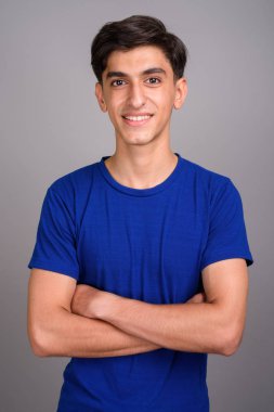 Gri arka planı gülümseyen genç mutlu İranlı genci