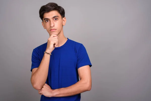 Jovem bonito adolescente persa contra fundo cinza — Fotografia de Stock