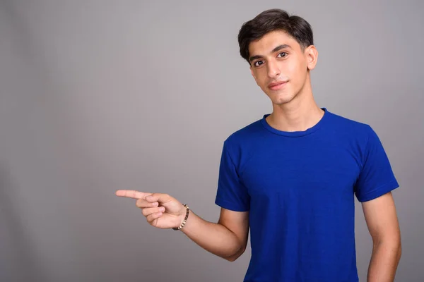 Junge hübsche persische Teenager-Junge zeigt mit dem Finger und zeigt Copyspace — Stockfoto