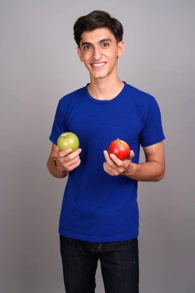 Молодий красивий Перська підлітком проведення здорового зеленого і червоного apple — стокове фото