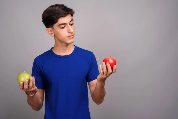 Молодий красивий Перська підлітком проведення здорового зеленого і червоного apple — стокове фото